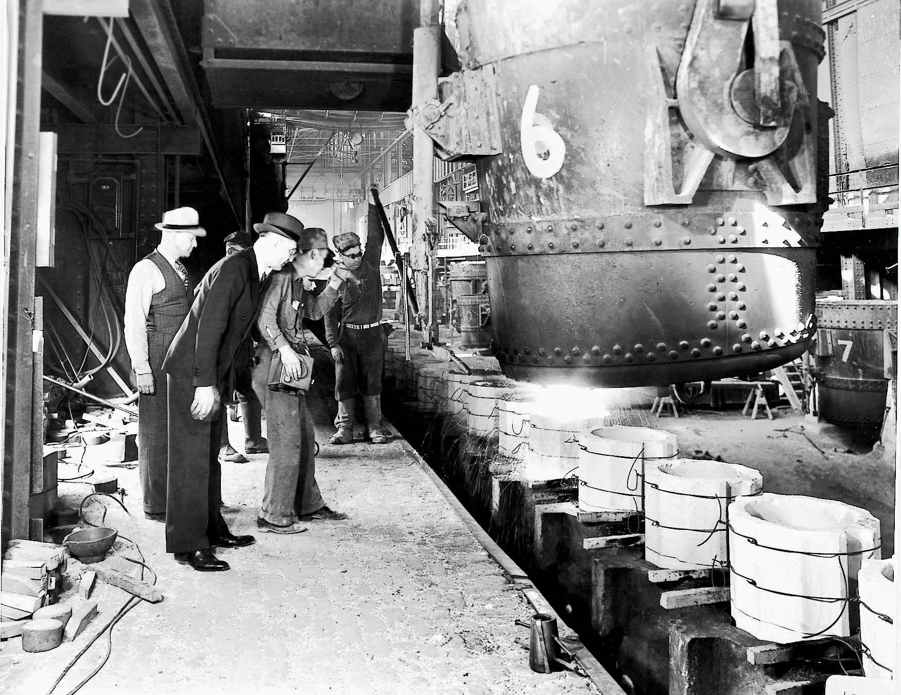 H.H. Timken (foreground) watches steel pouring at the company’s first melt shop in 1917. 